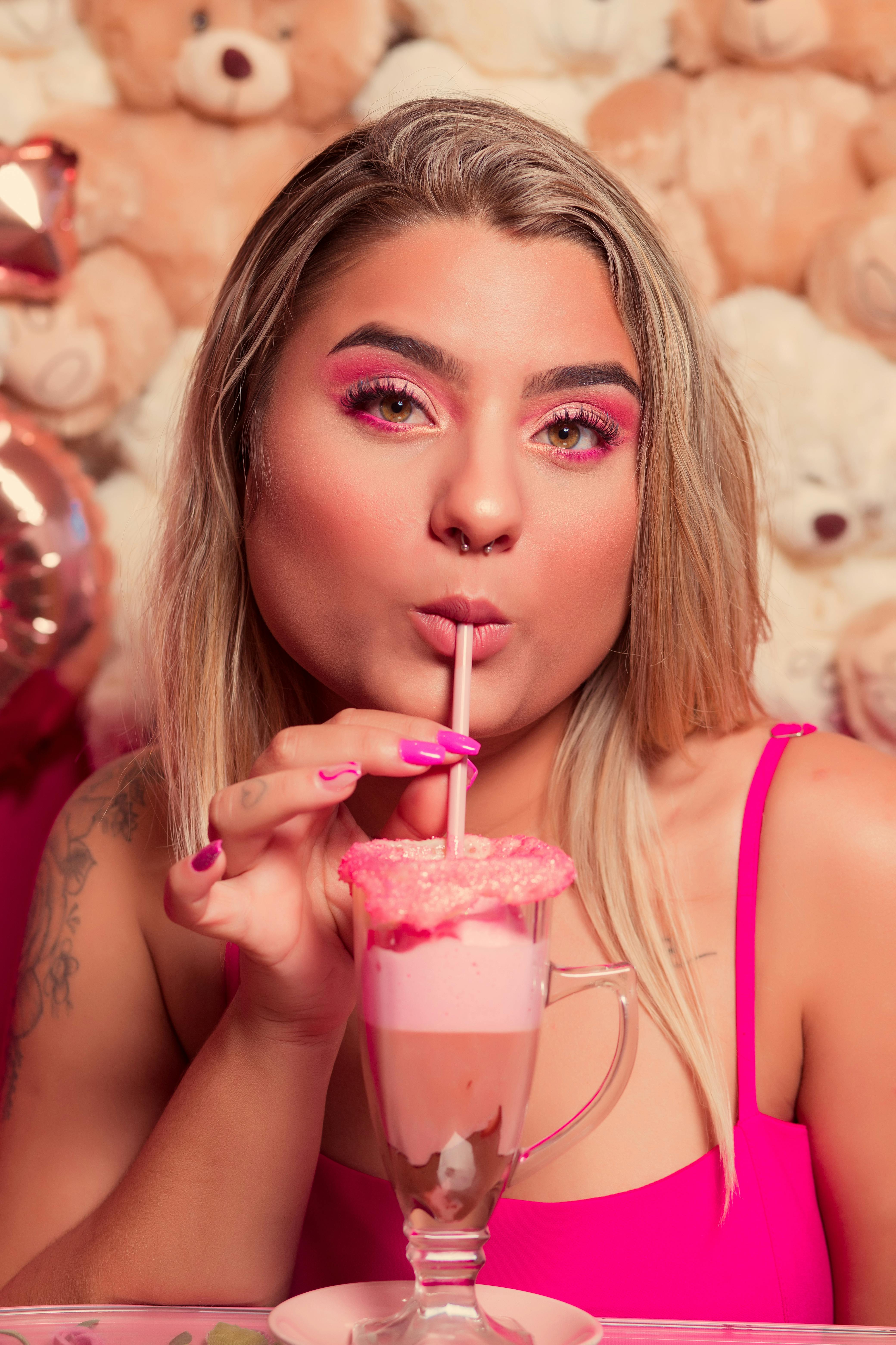 Garota toma milkshake à mesa